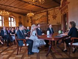 Standesbeamtin mit den Brautleuten und Trauzeugen, im Hintergrund die Gäste im mit Kronleuchtern und Wandbemalung festlich geschmückten Bürgersaal