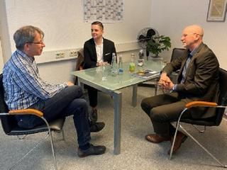 Bürgermeister Christ beim Firmenbesuch 3 Männer am Tisch