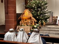 Kinder im Gewand der Heiligen Könige bei der feierlichen Aussegnung in der Liebfrauenkirche mit Krippe und geschmücktem Tannenbaum.