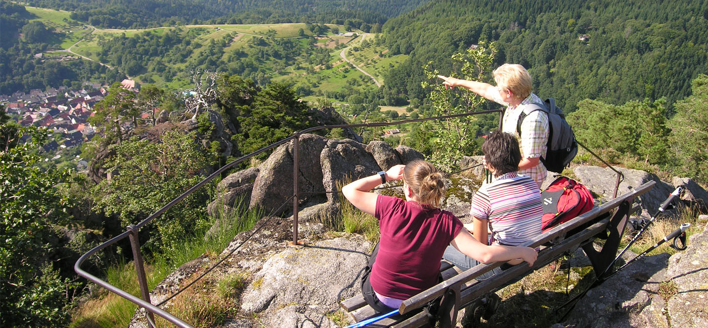 Drei Wanderer auf Bank genießen den Ausblick vom Lautenfelsen